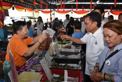 Mohd Shafie beramah mesra dengan peniaga ketika melakukan tinjauan mesra sempena sambutan Tahun Baharu Cina di Tamu Lido, Kota Kinabalu.