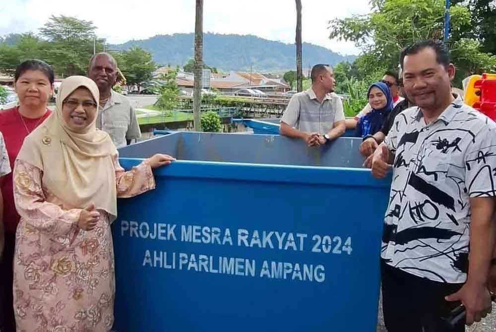 Rodziah (kiri) bergambar bersama penduduk sempena Majlis Serahan Tong Sampah di Ampang Jaya pada Sabtu.