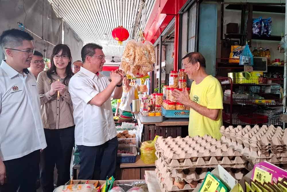 Kor Ming menyantuni peniaga di Pasar Taman Canning, Ipoh pada Ahad.