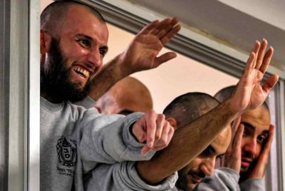 Banduan Palestin yang dibebaskan oleh Israel melambai kepada orang ramai yang berkumpul menyambut mereka di bangunan Pusat Sukan Perbandaran Ramallah. Foto AFP