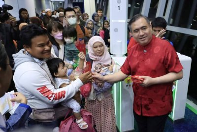 Anthony beramah mesra bersama penumpang penerbangan di Lapangan Terbang Antarabangsa Kuala Lumpur (KLIA) Terminal 1 pada Jumaat. Foto Bernama