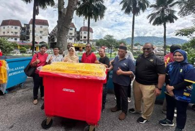 Rodziah (tiga dari kiri) dan Ramli (dua dari kanan) bergambar bersama penduduk sempena Majlis Serahan Tong Sampah di Ampang Jaya pada Sabtu.