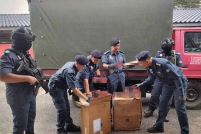 Wan Jamal (empat dari kiri) melihat rokok seludup yang dirampas di Pasir Mas Rabu lalu.