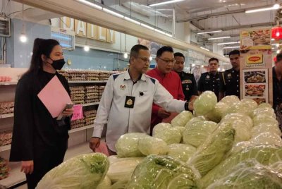 Azman (dua, kiri) melihat kobis ketika Program 'Walkabout' bagi Pematuhan Skim Harga Maksimum Musim Perayaan Tahun Baharu Cina 2025 pada Ahad.