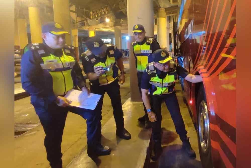 Van Lutam (kanan) memeriksa tayar bas dalam Op Tahun Baharu Cina 2025 di Terminal Bas Shahab Perdana, di sini, pada malam Ahad.