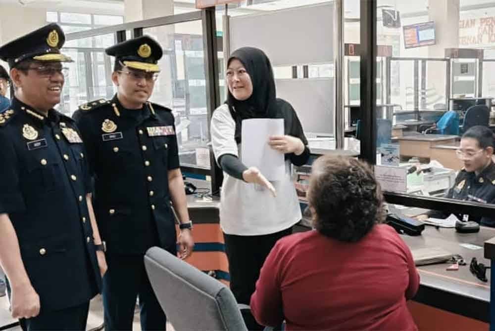 Aedy Fadly (kiri) diiringi Syed Ahmad Khirulanwar Alyahya mendekati pelanggan yang berurusan di kaunter sempena lawatan kerja beliau ke Ibu Pejabat JPJ Pahang, Indera Mahkota di sini pada Isnin.