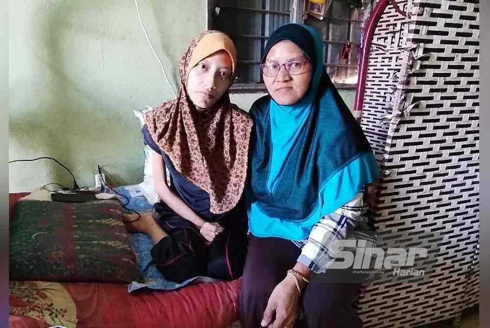 Wan Jah (kanan) bersama anaknya, Syafiqah ketika ditemui pemberita di Kampung La, Besut, baru-baru ini.