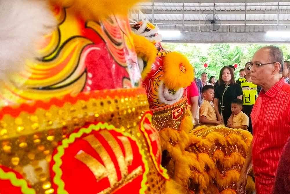 Wan Rosdy (kanan) tertarik melihat Tarian Singa ketika menghadiri Majlis Rumah Terbuka Tahun Baharu Cina 2025 di Dewan Serbaguna Sekolah Jenis Kebangsaan Cina (SJKC) Jerkoh, Kampung Baru Jerkoh, Lipis pada Isnin.