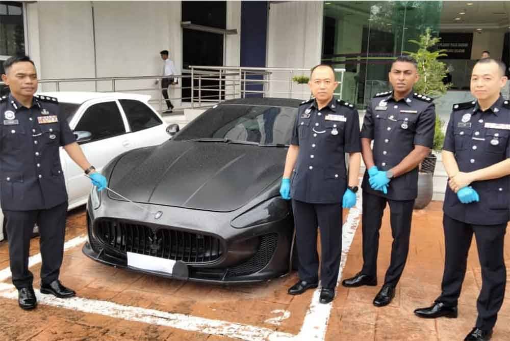 Raub (kiri) menunjukkan Maserati Granturismo yang dirampas pada sidang akhbar di IPD Johor Bahru Selatan, Johor Bahru, pada Isnin.