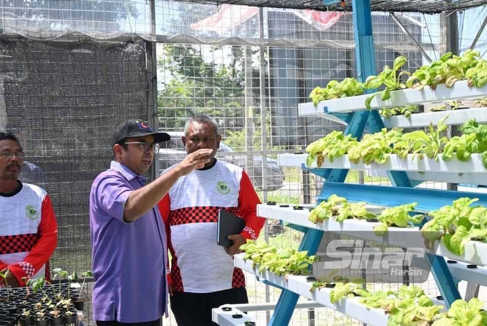 Hazif (tengah) meninjau perusahaan komuniti di bawah program SejaTi MADANI.