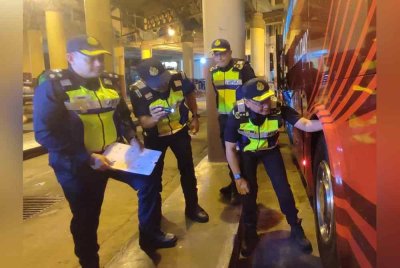 Van Lutam (kanan) memeriksa tayar bas dalam Op Tahun Baharu Cina 2025 di Terminal Bas Shahab Perdana, di sini, pada malam Ahad.