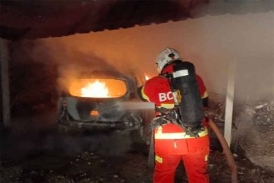 Anggota bomba memadam kebakaran membabitkan dua kenderaan yang diparkir di garaj di Batu 3 Ijok di Kuala Selangor pada Isnin.