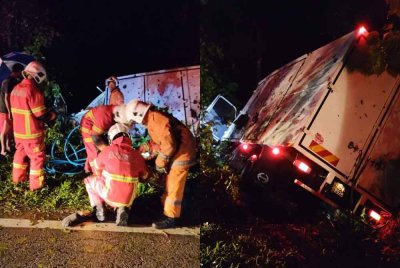Anggota bomba berusaha mengeluarkan pemandu lori yang tersepit dalam kemalangan di Sungai Sam, Kuala Krai.
