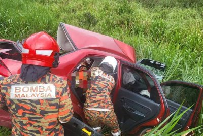 Anggota bomba mengeluarkan mangsa selepas kereta dipandunya terbabit nahas dengan sebuah treler di Jalan Batu Pahat-Mersing, Kluang pada Isnin.- Foto JBPM