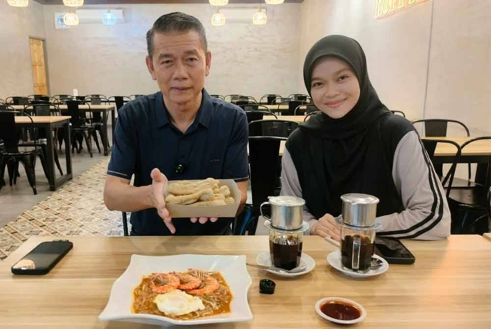 Ghazali menunjukkan menu kuetiau, keropok lekor dan kopi tenggek yang disediakan di kafenya.