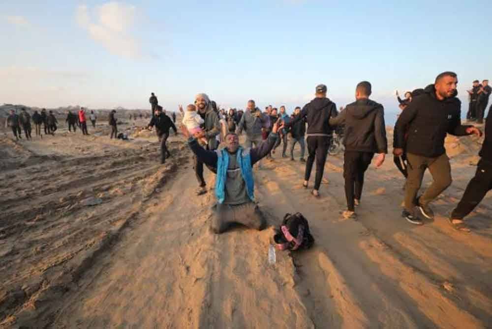 Seorang lelaki melutut tanda gembira kerana dapat kembali ke utara Gaza. Foto Agensi