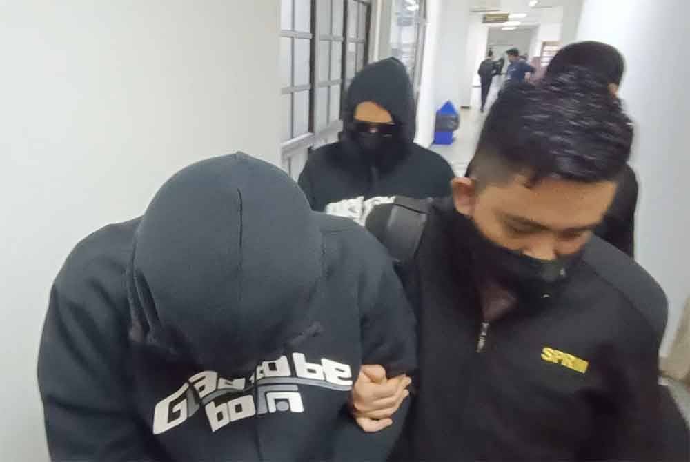 Mohd Khairul Saberi (depan) dan Michael dihadapkan ke Mahkamah Sesyen Johor Bahru, pada Selasa atas tuduhan meminta, memperoleh dan setuju terima rasuah.