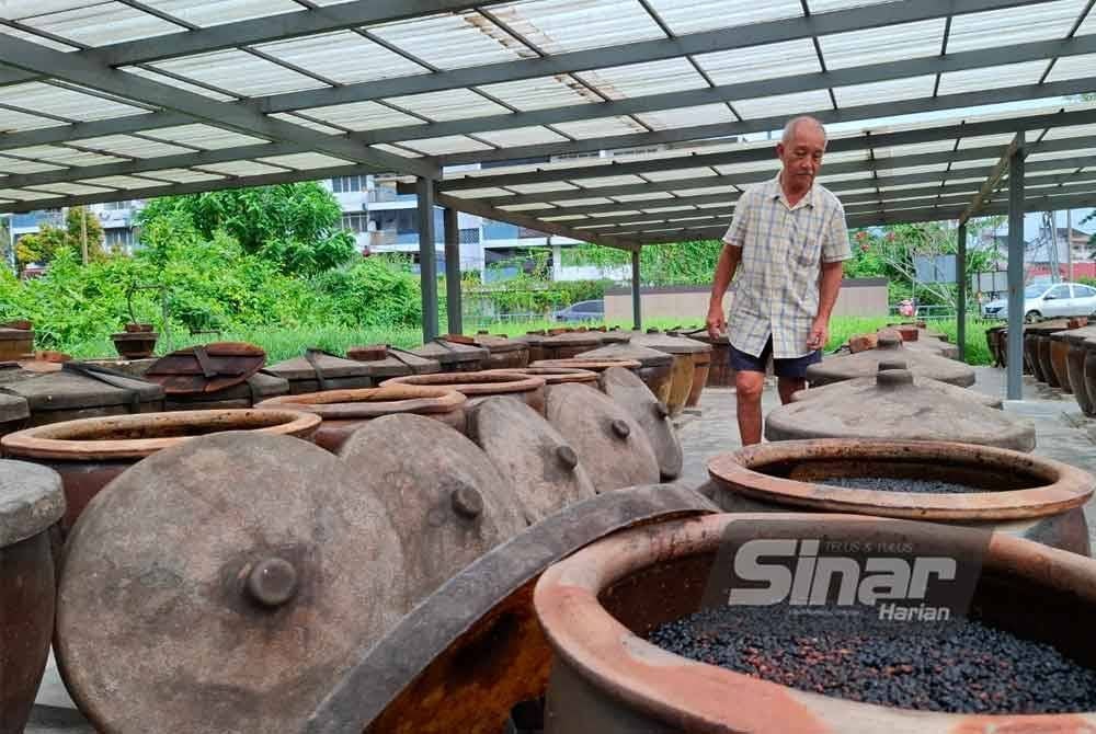 Pak Tong merenung sayu deretan tempayan yang sebelum ini digunakan dalam penghasilan kicap di kilangnya di Kampung Rawa Baru, Gopeng.