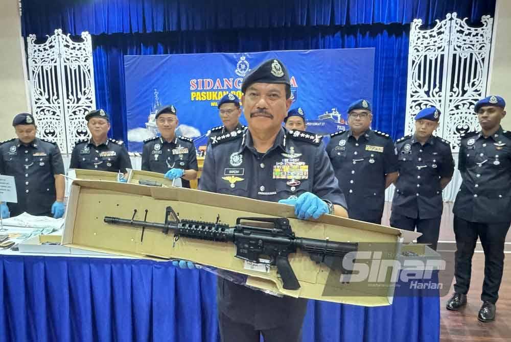 Hamzah menunjukkan salah satu senjata api dirampas iaitu selaras senapang dari salah sebuah bot gentian kaca pada Isnin.