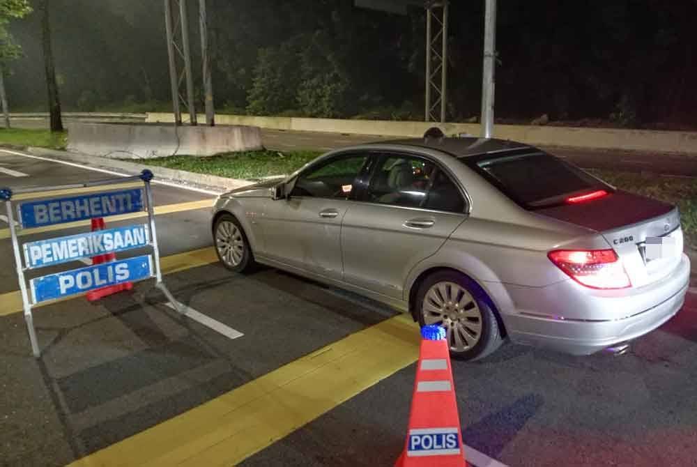 Anggota polis memeriksa kenderaan dalam sekatan jalan raya di Jalan Langat, Klang pada Rabu.