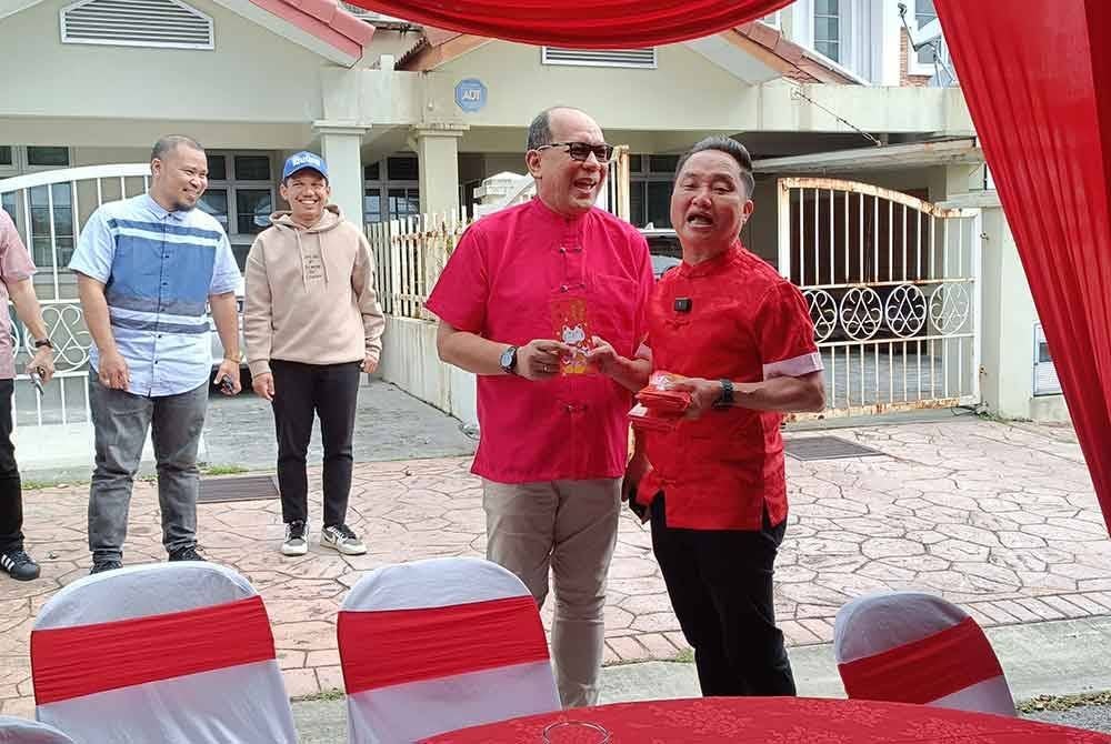 Suee Lim (kanan) dan Izham (kiri) ketika majlis rumah terbuka bagi perayaan Tahun Baru Cina di sini pada Rabu.