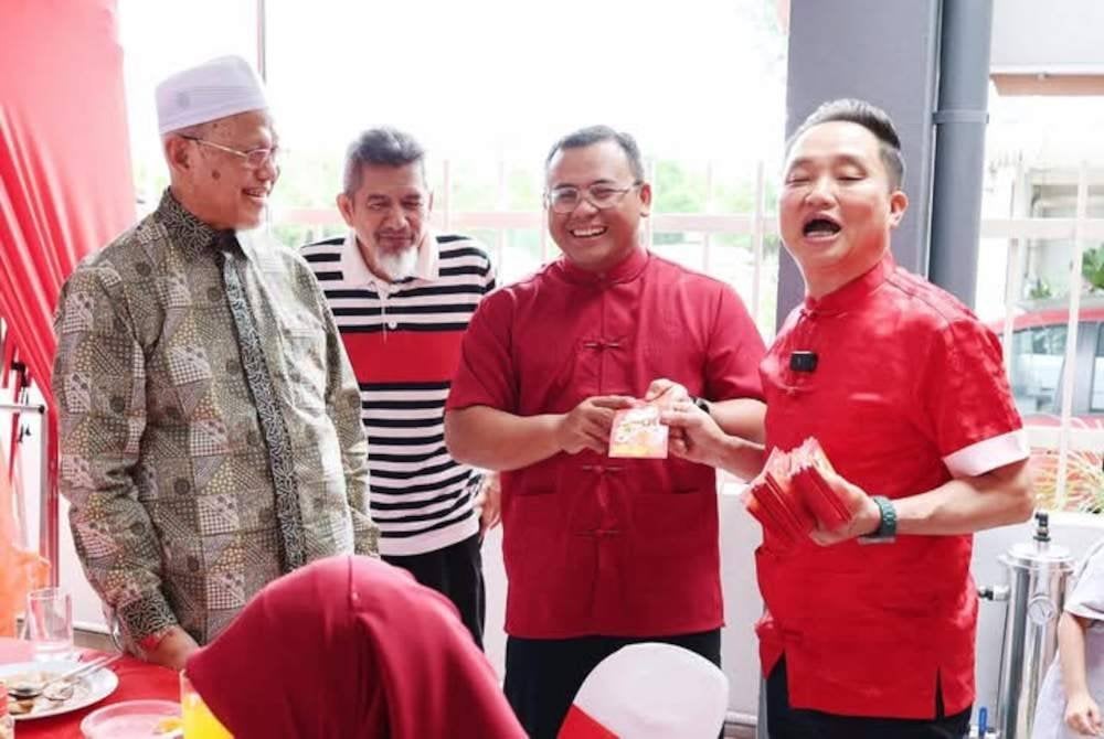 Amirudin (dua dari kanan) bersama Mohd Tamyes (kiri) ketika menghadiri rumah terbuka Suee Lim (kanan) sempena sambutan Tahun Baharu Cina.