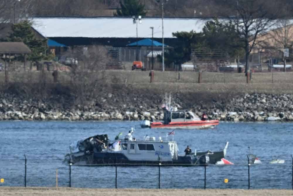 Sebuah bot polis mengumpulkan bangkai kapal di sepanjang Sungai Potomac selepas penerbangan American Airlines 5342 terhempas ke dalam sungai akibat berlanggar dengan helikopter tentera AS, berhampiran Washington, DC pada 30 Januari. Foto AFP