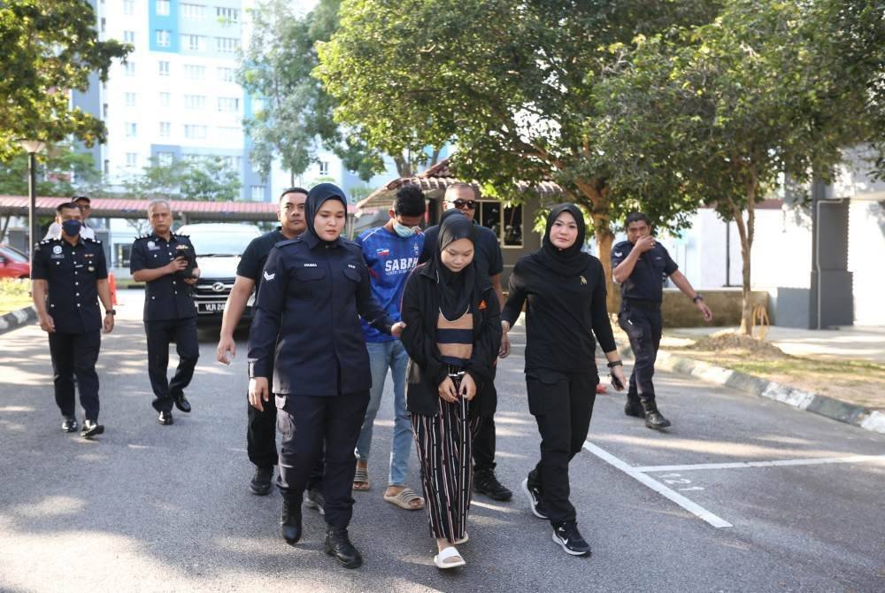 Pasangan kekasih berkenaan diiringi anggota polis sebaik tiba di pekarangan mahkamah.