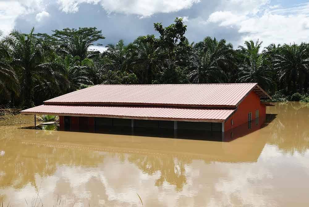 Sebuah rumah ditenggelami air dari limpahan air Sungai Labuk yang mengakibatkan banjir di Kampung Ganah Jati. Foto Bernama