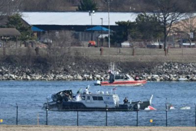 Sebuah bot polis mengumpulkan bangkai kapal di sepanjang Sungai Potomac selepas penerbangan American Airlines 5342 terhempas ke dalam sungai akibat berlanggar dengan helikopter tentera AS, berhampiran Washington, DC pada 30 Januari. Foto AFP