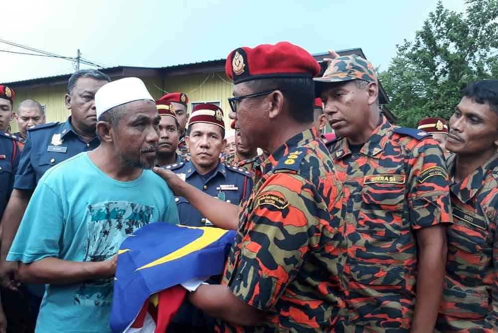 Shamsol (dua,kanan) ketika bertemu waris salah seorang anggota bomba yang maut ketika menjalankan operasi mencari dan menyelamat remaja lemas pada 3 Oktober 2018.