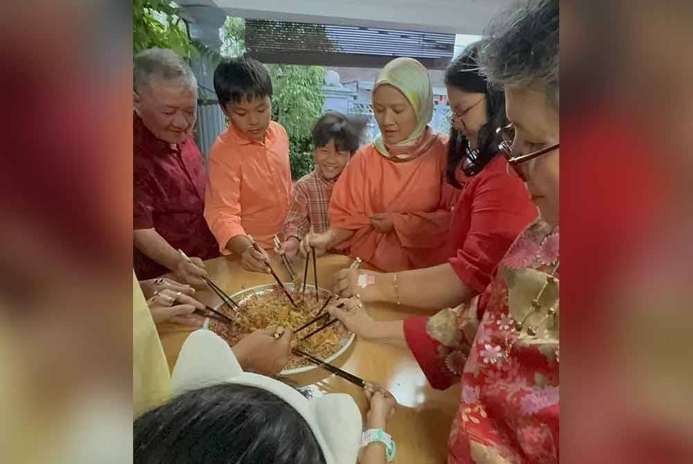 Keluarga Muhammad Nazri menggaul yee sang ketika makan besar pada malam sambutan Tahun Baru Cina, Selasa lalu.