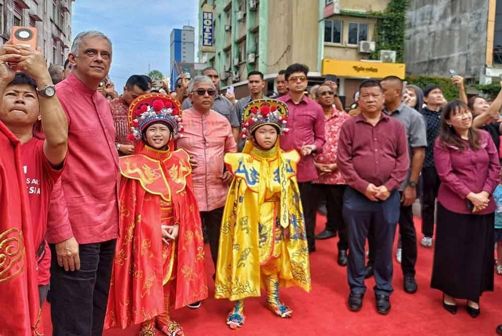 Yu Man (kanan) mengiringi Al-Sultan Abdullah (empat dari kiri) dan Tengku Hassanal (tiga dari kanan) ketika Majlis Sambutan Tahun Baharu Cina di pekarangan Menara Kuantan 188 pada Sabtu.