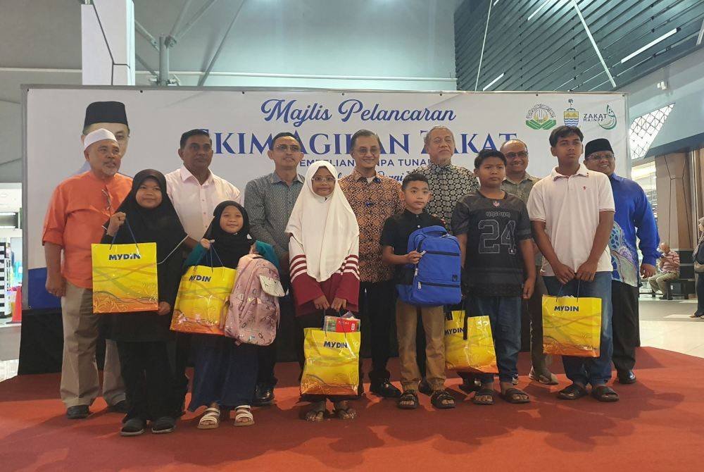 Mohamad (tengah) bergambar dengan sebahagian penerima sumbangan Majlis Agihan Zakat Pembelian Tanpa Tunai 'Kembali ke Sekolah 2025 di Mydin Bukit Mertajam pada Sabtu.