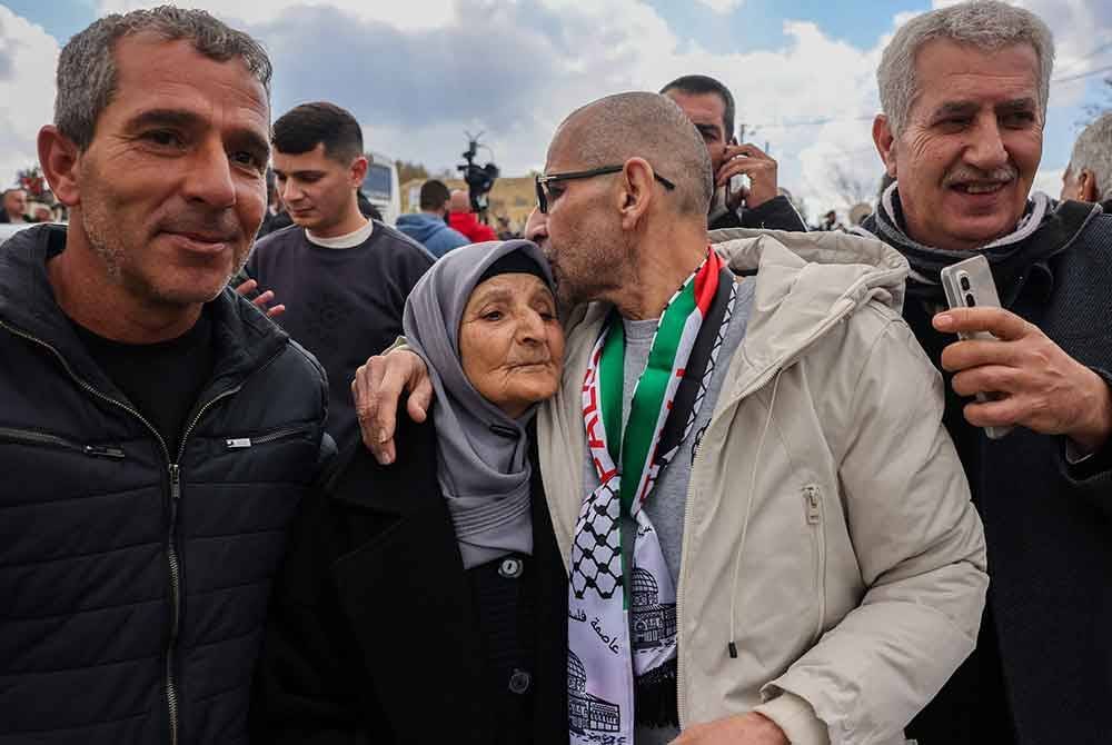Seorang bekas tahanan Palestin yang dibebaskan oleh Israel disambut oleh ibunya sebaik tiba di Ramallah dengan bas daripada ICRC. Foto AFP