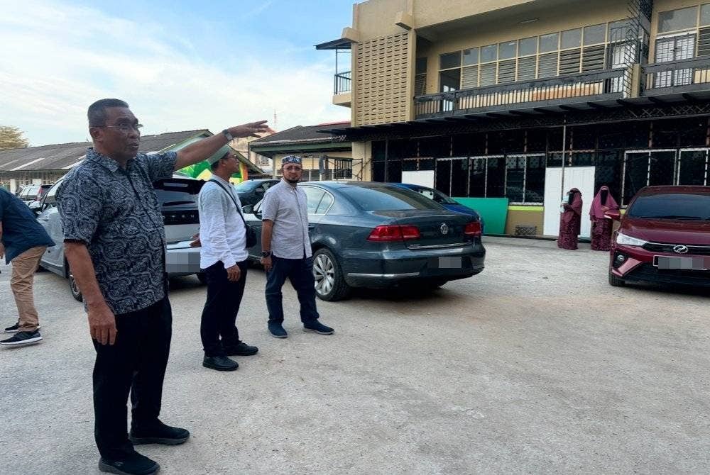 Takiyuddin (kiri) menunjukkan bangunan SRITI di Kampung Sireh.