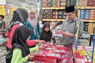 Razak (kanan) ketika menyantuni anak-anak yatim memilih keperluan mereka untuk sesi persekolahan 2025. - Foto ihsan Razak Daud