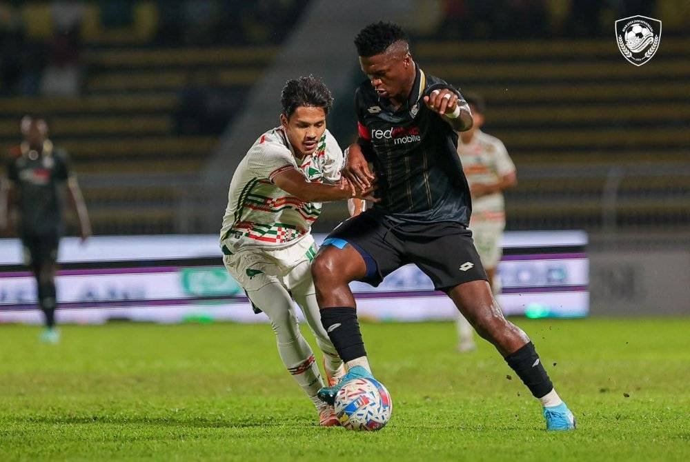 Penyerang muda KDA FC, Mohd Aiman Afif Md Afizul (kiri) dikawal ketat pertahanan PDRM FC pada separuh akhir kedua MFL Challenge Cup di Stadium Darul Aman pada malam Sabtu. Foto KDA FC