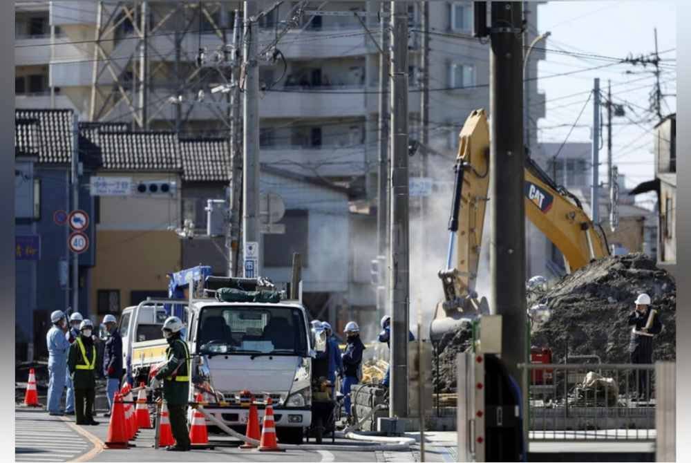 Pasukan penyelamat membina tanjakan untuk menyelamatkan pemandu trak yang tersepit dalam lubang benam di Yashio, Jepun - Foto Agensi