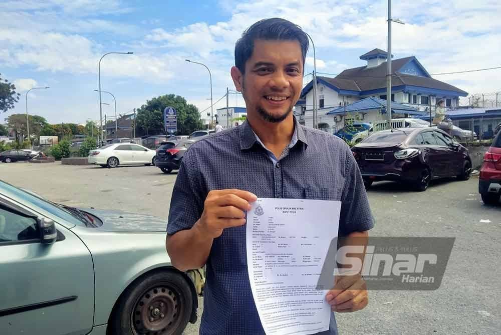 Hasnul Zulkarnain menunjukkan laporan yang dibuat di IPD Ipoh pada Ahad.