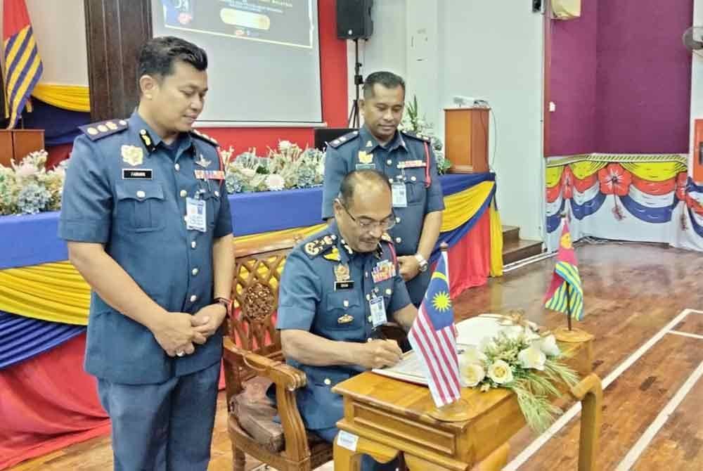 Ahmad Izram (tengah) menandatangani kehadiran ke JBPM Tunjong sempena Program Sumbangan Kebajikan Persatuan Kebajikan Dengan Kerjasama Biro Kebajikan Perisma.