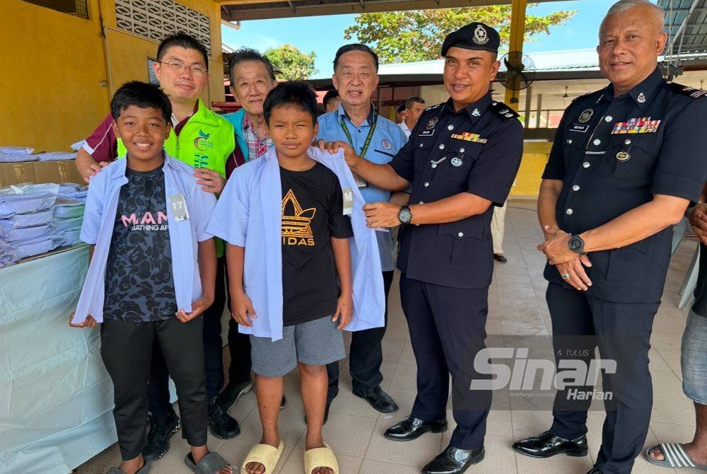 Kanak-kanak menerima bantuan baju sekolah baharu di Tumpat. Foto SINAR HARIAN ADILA SHARINNI WAHID