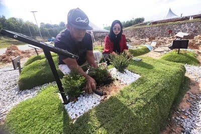 Menjadi rutin Marinah (kanan) dan Nor Hisham menziarahi pusara arwah pasangan masing-masing.