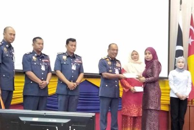 Ahmad Izram (empat dari kanan) menyampaikan sumbangan kepada waris anggota bomba yang meninggal dunia.