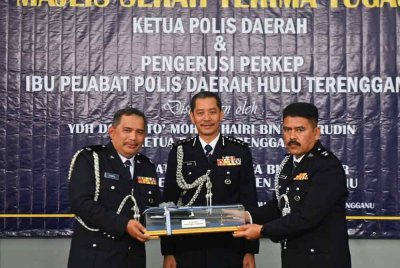 Mohd Khairi (tengah) menyaksikan serah terima tugas antara Sharudin Abdul Wahab (kanan) dan Zainul Mujahidin Mat Yudin (kiri) di perumahan Ibu Pejabat Polis Daerah Hulu Terengganu, Terengganu pada Isnin.