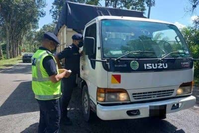 Anggota JPJ membuat pemeriksaan dokumen terhadap pemandu kenderaan barangan - Foto: JPJ