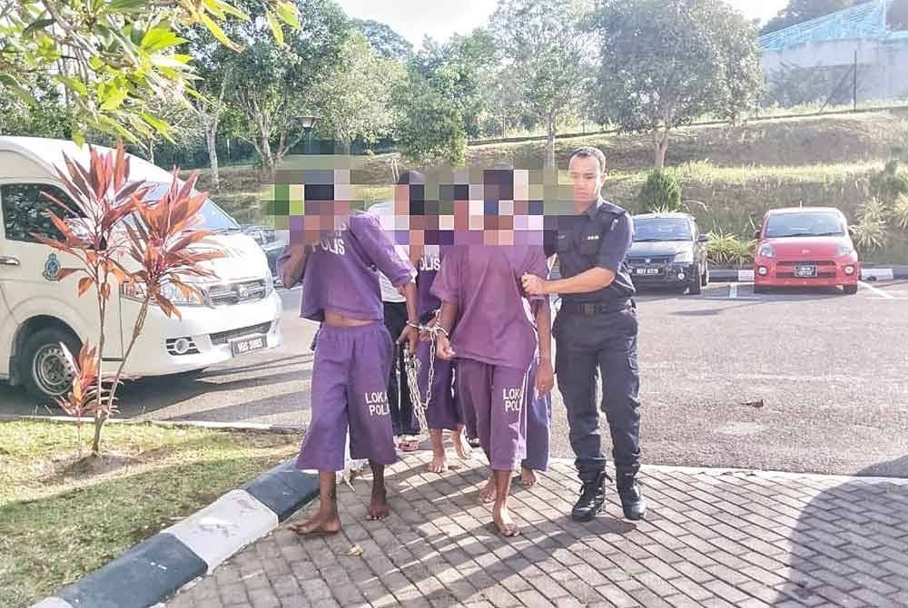 Suspek (kiri) tiba di pekarangan Mahkamah Alor Gajah di sini, pada Selasa.