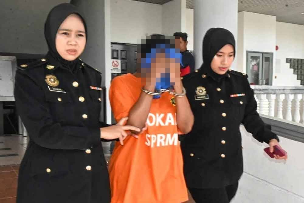 Suspek berusia 42 tahun (tengah) dibawa ke Mahkamah Majistret Melaka untuk direman pada Selasa.