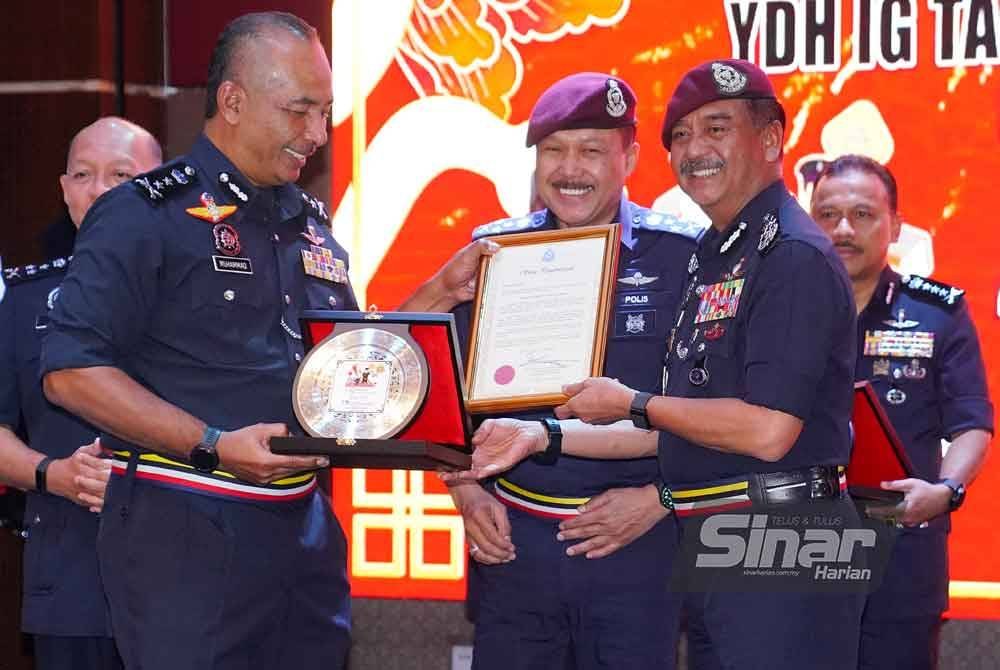 Razarudin (kanan) menyampaikan penghargaan kepada Muhammad Abdul Halim bagi kontinjen terbaik Op Selamat 23 Tahun Baharu Cina. Foto: MOHD HALIM ABDUL WAHID
