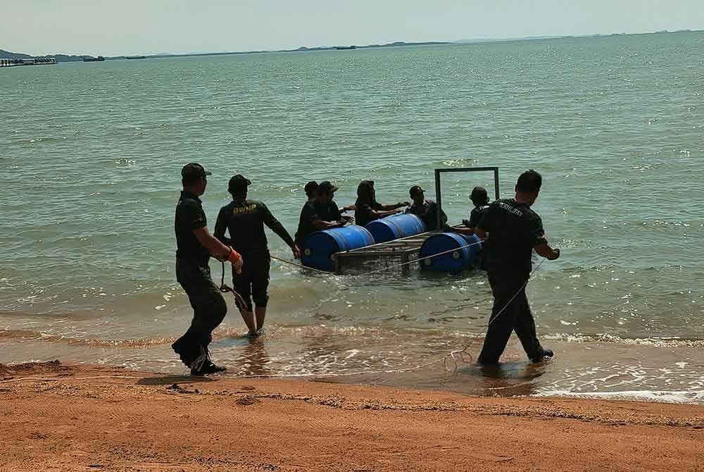 Anggota Perhilitan memasang perangkap buaya di Pantai Cermin, Port Dickson pada Selasa.